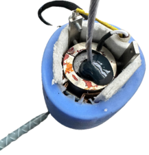 Optimized resin formulation cast into the rope socket cavity during a validation build, cable strands visible below